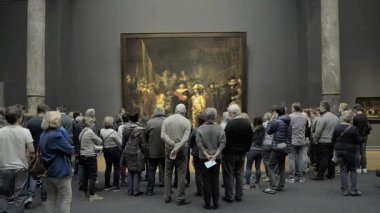 AMSTERDAM, NETHERLANDS - 10 Mayıs 2017: Rijksmuseum 'daki The Night Watch veya The Militia Company of Captain Frans Banning Cocq filmini izleyen insanlar