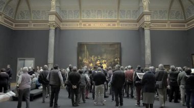 AMSTERDAM, NETHERLANDS - 10 Mayıs 2017: Rijksmuseum 'daki The Night Watch veya The Militia Company of Captain Frans Banning Cocq filmini izleyen insanlar