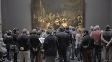 AMSTERDAM, NETHERLANDS - 10 Mayıs 2017: Rijksmuseum 'daki The Night Watch veya The Militia Company of Captain Frans Banning Cocq filmini izleyen insanlar