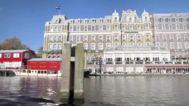 AMSTERDAM, NETHERLANDS - 10 Mayıs 2017: Amsterdam 'daki eski Amstel Oteli' nin yanından geçiyor