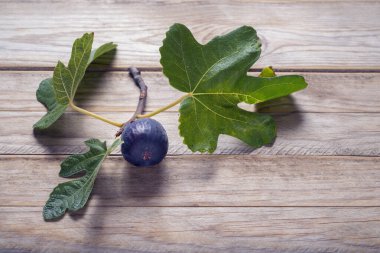 Tahta bir masanın üzerindeki incirin yakın çekimi.