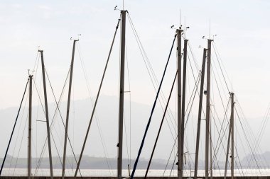 Tekne bulutlu gökyüzünün altında direkler