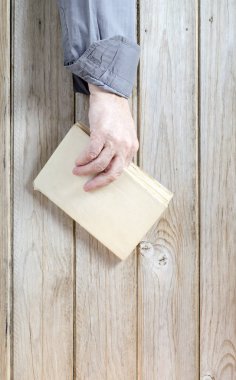 El ele kitap tutuş. Ahşap arkaplan