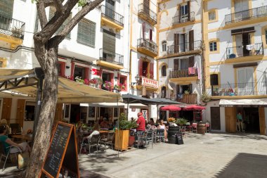 IBIZA, İspanya - 11 Mayıs 2015 İbiza Eski Kasabası. Beyazlatılmış evleri ve sokak restoranlarıyla eski İbiza kasabasının pitoresk bir caddesi. 