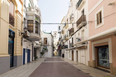 IBIZA, İspanya - 13 Mayıs 2015: İbiza Eski Kasabası. Eski İbiza şehrinin resimli bir caddesi, beyazlatılmış evleri ve asılmış kıyafetlerle dolu balkonları.. 