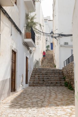 IBIZA, İspanya - 13 Mayıs 2015: İbiza Eski Kasabası. Eski İbiza şehrinin resimli bir caddesi, beyazlatılmış evleri ve asılmış kıyafetlerle dolu balkonları.. 