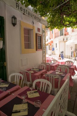 IBIZA, İspanya - 11 Mayıs 2015 İbiza Eski Kasabası. Beyazlatılmış evleri ve sokak restoranlarıyla eski İbiza kasabasının pitoresk bir caddesi.