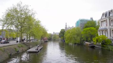 AMSTERDAM, NETHERLANDS - 10 Mayıs 2017: Amsterdam 'ın tarihi merkezinde bir kanalın yanındaki küçük saray