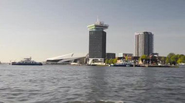 AMSTERDAM, NETHERLANDS - 10 Mayıs 2017: İlkbaharda Amsterdam kanallarında yelken açmak, Hollanda EYE Film Enstitüsü manzarası. Hollanda 'da Hollanda arşivi ve müzesi olup Hollanda' da gösterilen filmleri saklar ve sunar.