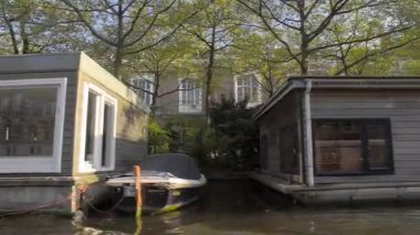 AMSTERDAM, NETHERLANDS - 10 Mayıs 2017: İlkbaharda Amsterdam kanallarında yelken açmak, yüzen evler