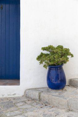 İbiza 'da dar bir caddenin basamaklarında mavi tencere.