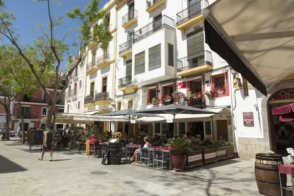 IBIZA, İspanya - 11 Mayıs 2015 İbiza Eski Kasabası. Beyazlatılmış evleri ve sokak restoranlarıyla eski İbiza kasabasının pitoresk bir caddesi. 
