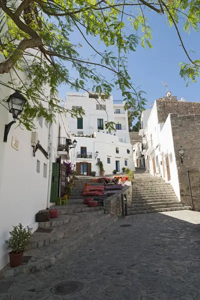 IBIZA, İspanya - 15 Mayıs 2015 İbiza Eski Kasabası. Beyazlatılmış evleri ve sokak restoranlarıyla eski İbiza şehrinin pitoresk bir caddesi.