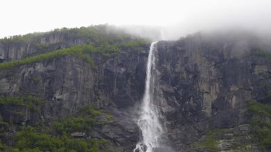 Briksdalsbreen buzuluna giden yürüyüş yolunda dağ yamaçları ve şelaleler. Gelin, Norveç.
