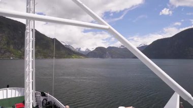 Norveç 'te fiyortta yelken açan dağların manzarası ve feribot. Storfjorden feribottan görüldüğü gibi.