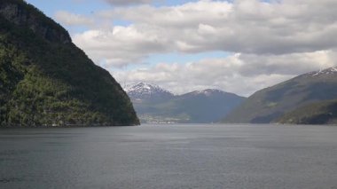 Norveç 'te fiyortta yelken açan dağların manzarası ve feribot. Storfjorden feribottan görüldüğü gibi.