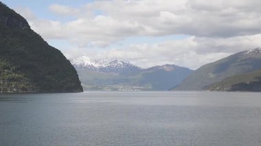Norveç 'te fiyortta yelken açan dağların manzarası ve feribot. Storfjorden feribottan görüldüğü gibi.