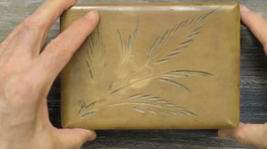 Bir adamın elleri içinde anahtar ve kırmızı kalp olan bir kutuyu açar.