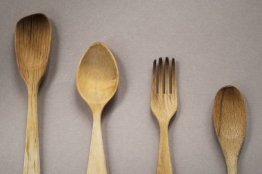 Tek renkli arka planda ahşap çatal bıçak seti yakın plan. Boşluğu kopyala