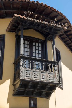 LA OROTAVA, TENERIFE, SPAIN - 23 Haziran 2015: Tarihi şehir merkezinde geleneksel oyma ahşap balkonu olan eski ev (şimdi bir giyim mağazası)