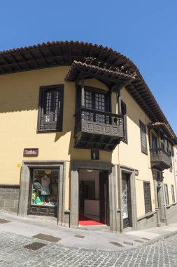 LA OROTAVA, TENERIFE, SPAIN - 23 Haziran 2015: Tarihi şehir merkezinde geleneksel oyma ahşap balkonu olan eski ev (şimdi bir giyim mağazası)