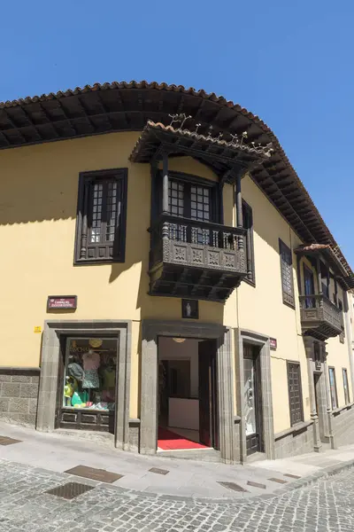 LA OROTAVA, TENERIFE, SPAIN - 23 Haziran 2015: Tarihi şehir merkezinde geleneksel oyma ahşap balkonu olan eski ev (şimdi bir giyim mağazası)