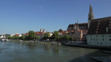 REGENSBURG, GERMANY - 13 Haziran 2019: Tuna Nehri üzerindeki ortaçağ taş köprüsünden bakıldığı gibi Regensburg şehir manzarası. Şehrin ortaçağ merkezi UNESCO Dünya Mirasları Alanıdır..