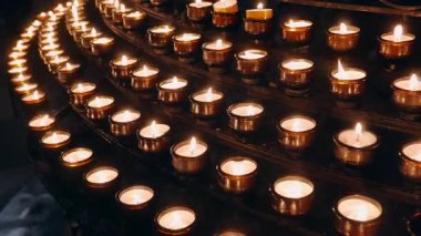 Loş bir kilisede yanan mumlar.