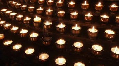 Loş bir kilisede yanan mumlar.