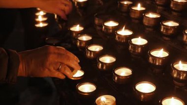 Loş bir kilisede yanan mumlar.