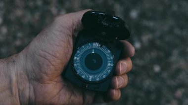 Bir adam gün batımında bir pusula ile kendini yönlendirmeye çalışır.