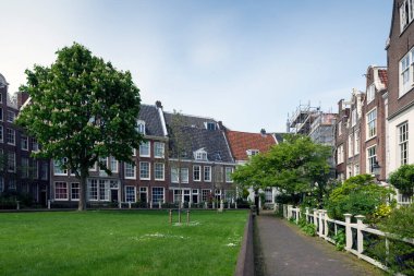 AMSTERDAM, NETHERLANDS - 15 Mayıs 2017: The Begijnhof Amsterdam 'ın en eski iç mahkemelerinden biridir. Çoğunlukla özel konutlar olmak üzere bir grup tarihi bina bu konutun merkezinde yer alıyor..