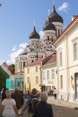 TALLINN, ESTONIA - 12 Haziran 2016: Tallinn 'de merkez bir caddede turist, arka plandaki kubbeler Alexander Nevsky Katedrali, Estonya' nın Tallinn şehrinde bir Ortodoks Katedrali.