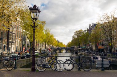 AMSTERDAM, NETHERLANDS - 9 Mayıs 2017: güneşli bir bahar öğleden sonrasında bir kanal üzerinde köprü