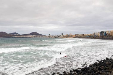 LAS PALMAS DE GRAN Kanada - 29 Temmuz 2016: Las Canteras sahilinde yüzücüler ve sörfçüler Las Palmas, Kanarya Adaları