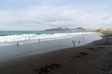 LAS PALMAS DE GRAN Kanada - 3 AĞUSTOS 2016: Las Canteras sahilinde yüzücüler ve sörfçüler Las Palmas, Kanarya Adaları