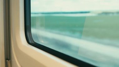 Hareket halindeki bir trenin penceresinden dışarıya odaklanmamış görünüm