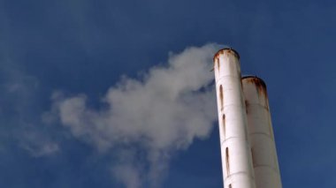 Mavi gökyüzü üzerinde dumanlı bacalar. kış sabahı