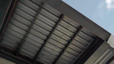 Aşağıdan görünen bir endüstriyel geçitin metal yapısında dolaşıyordu.