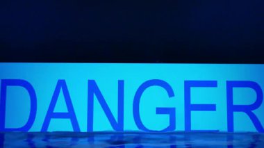 'DANGER' kelimesi su seviyesiyle kaplıdır.