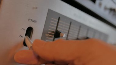 Bir adam analog ses eşitleyicisini açar ve ayarlar