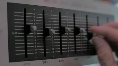Bir adam dengeleyicinin sürgülü ayarlarını manipüle eder. yakın plan