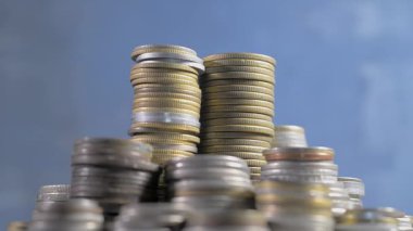 Yığınla bozuk para dönüyor. mavi arka plan. Kusursuz döngü