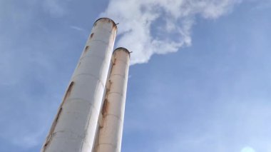 Mavi gökyüzü üzerinde dumanlı bacalar. kış sabahı