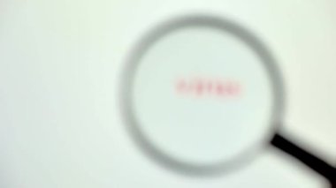 Bir el, bir bilgisayar virüsünü bulmak için bir büyüteç tutuyor.