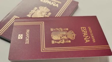Beyaz arkaplanda dönen İspanyol pasaportlarının yakın plan görüntüleri