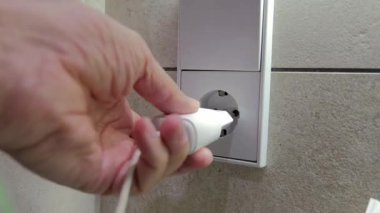 Erkek el Avrupa elektrik prizini bir duvar prizine bağlıyor