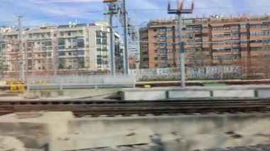 Bir şehrin binalarının penceresinden bir trenin manzarası