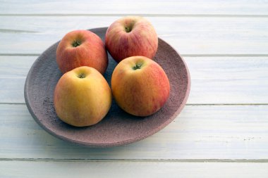 Çanak çömlekte dört elma.