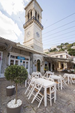 HYDRA, GREECE - 25 Ekim 2015: Hydra limanındaki rıhtımdaki kafelerin teraslarındaki insanlar